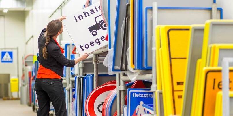 persoon bij verkeersborden in opslag